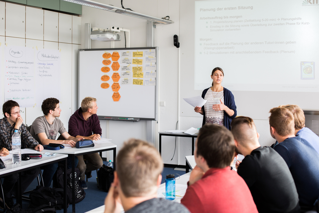 Lehrerin führt ein Unterricht von der Gruppe von Studierenden durch.
